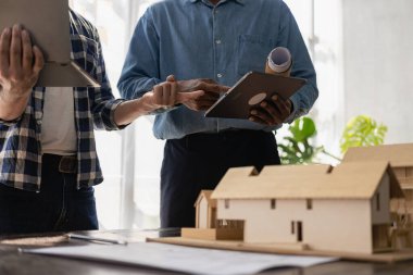 İki erkek müfettiş ve mimar tartışıyorlardı. Arka planda ortaklarla etkileşime giren mühendislik projesinde baş mühendis..