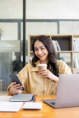 Evden çalışan hırslı Asyalı kız dizüstü bilgisayar ekranlarına ve mali belgelere bakıyor, kadın uzaktan çalışırken e-postaları kontrol ediyor veya araştırma yapıyor.