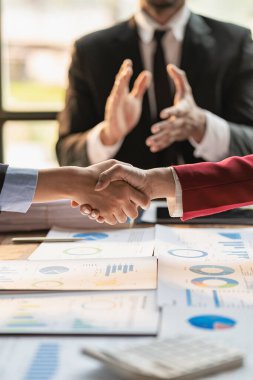 Şirketteki ticari hizmetleri geliştirmek için yeni bir yazılım geliştirme sözleşmesi imzalayan iki işadamıyla yapılan görüşmenin ardından adaylarla el sıkışmak.