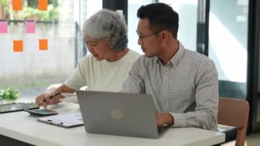 Ofis masasında dokümanlar üzerinde yapılan çok nesilli bir takım toplantısında iş ortaklarının görüşmeleri. Raporları, stratejileri, şirket hakkındaki proje planlarını tartışırız. iş ortağı