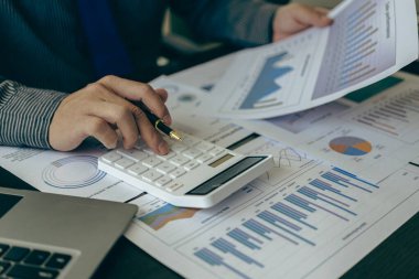 Hesap makinesine güvenen ve bilgisayarla yakın plan muhasebe konseptini elinde tutan muhasebeci. Matematik finansmanı, analitik araştırma konsepti.