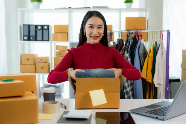 stock image Asian female entrepreneur SME business owner works with laptop, box and phone to shop online at home. Online Marketing SME Ecommerce Online Packaging Delivery