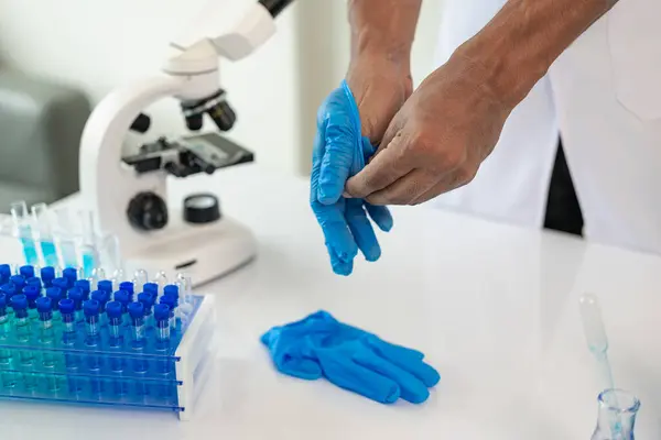 Professional medical surgeon takes off rubber gloves after surgery, copyrights sterile hygiene protective clothing, ends medical career. Close-up pictures