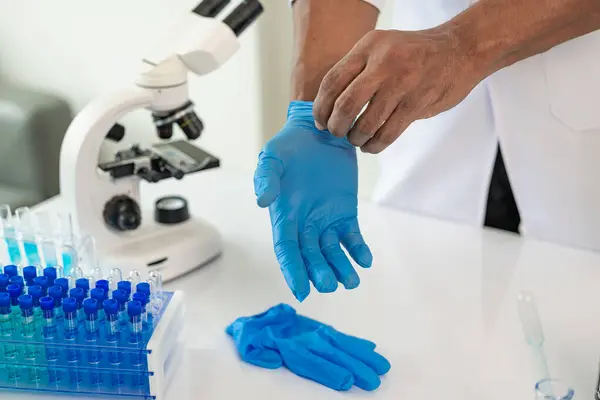 Professional medical surgeon takes off rubber gloves after surgery, copyrights sterile hygiene protective clothing, ends medical career. Close-up pictures
