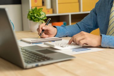 İş adamı, grafik ve grafik veri analizi için iş belgesine işaret ediyor ve elinde kalem tutan ve kar kavramını analiz etmek için mali belgeleri işaret eden muhasebe işkadını