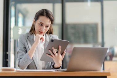 Profesyonel iş kadını, kurumsal pazarlama müdürü, elinde dijital tablet bulunan kadın işçi, tablette yeni bir girişimin bilgilerini okuyor ve iş stratejisi ve planlarını inceliyor..