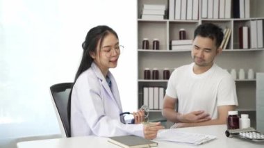 Güzel kadın doktor kalp ve akciğer fonksiyonlarını dinlemek için steteskop kullanıyor. Hastanedeki steteskoplu adam. Sağlık sorunları, hastalık konsepti. Video 4k