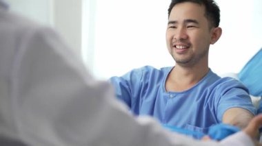 Hastanede erkek hastaların fizyoterapisine yardım eden hemşire, Asyalı kadın fizyoterapist çalışan ve hastaların ellerini korumaya yardım eden. Hasta klinikte kaslarını esnetiyor.