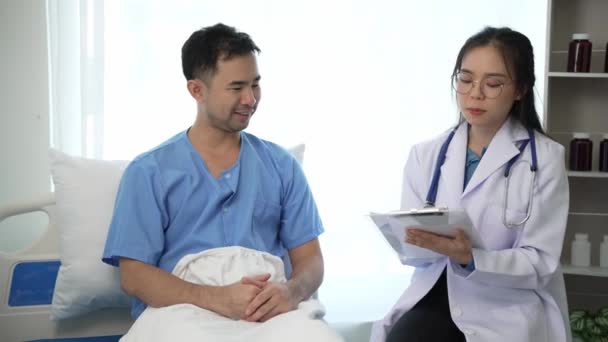 Junge Asiatische Ärztin Und Junge Männliche Patientin Liegen Auf Dem — Stockvideo