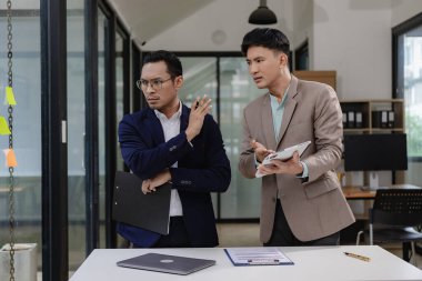 Kızgın işadamı iş yerindeki belge hatasıyla ilgili olarak işadamıyla tartışıyor. Yöneticiler kötü performans ve stresli toplantı kavramının sorumluluğuyla ilgili anlaşmazlık yaşıyorlar.