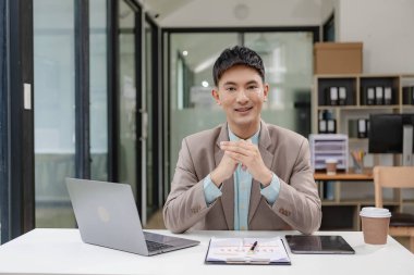 İş adamı, yönetici, CEO, yakışıklı Asyalı adam, ofiste oturan orta yaşlı adam, evrak işleriyle uğraşıyor, belgeleri kontrol ediyor ve okuyor, kontratlar ve dizüstü bilgisayarla muhasebe raporları..