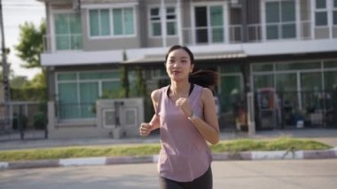Genç Asyalı koşucu ormanda ya da parkta koşuyor. Çekici fitness kadınlarında sağlıklı bir yaşam tarzı. Spor yapıyor, dışarıda egzersiz yapıyor.