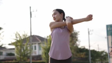Güzel Asyalı kadın spor yapıyor, doğa parkında egzersiz yapmadan önce ya da sonra esniyor, yaşam tarzı, spor, sağlık için uygunluk.