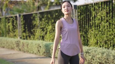 Güzel Asyalı kadın spor yapıyor, doğa parkında egzersiz yapmadan önce ya da sonra esniyor, yaşam tarzı, spor, sağlık için uygunluk.