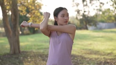 Güzel Asyalı kadın spor yapıyor, doğa parkında egzersiz yapmadan önce ya da sonra esniyor, yaşam tarzı, spor, sağlık için uygunluk.