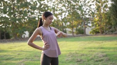 Güzel Asyalı kadın spor yapıyor, doğa parkında egzersiz yapmadan önce ya da sonra esniyor, yaşam tarzı, spor, sağlık için uygunluk.
