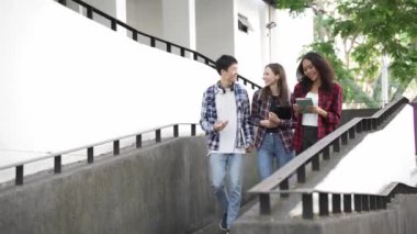 Birkaç nesil boyunca parlak genç öğrenciler parkta sınavlar için hazırlanıyorlar. Birlikte kitap okuyun ve dizüstü bilgisayar eğitimi kavramını kullanın. Akıllı öğrenci öğretmeniyle açık havada mutlu bir ders alıyor..