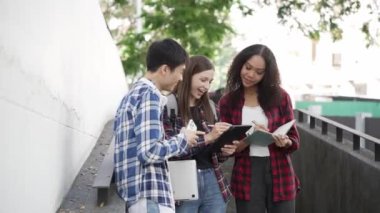 Birkaç nesil boyunca parlak genç öğrenciler parkta sınavlar için hazırlanıyorlar. Birlikte kitap okuyun ve dizüstü bilgisayar eğitimi kavramını kullanın. Akıllı öğrenci öğretmeniyle açık havada mutlu bir ders alıyor..