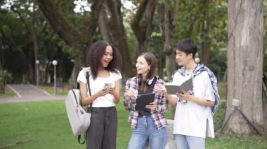 Birkaç nesil boyunca parlak genç öğrenciler parkta sınavlar için hazırlanıyorlar. Birlikte kitap okuyun ve dizüstü bilgisayar eğitimi kavramını kullanın. Akıllı öğrenci öğretmeniyle açık havada mutlu bir ders alıyor..