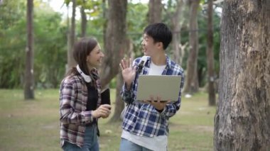 Komik gülümseyen gençler şehir parkında oturuyor ve açık havada sınavlara hazırlanıyor. Gençler kitap okur, notlar alır ve parkta ekose kumaşı tartışır, ders çalışır.