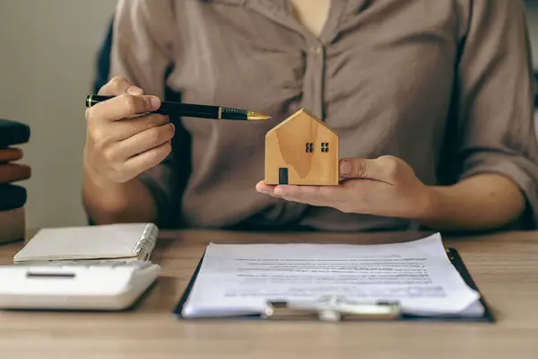A salesperson or broker offers a special promotion and free insurance to a customer who purchases a real estate sample home is reviewing documents before the customer agrees to sign a contract to purchase a home in the project.