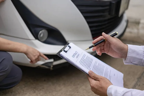 在交通事故和保险概念 特写照之后 保险工作人员正在检查损坏的汽车和客户签名 — 图库照片