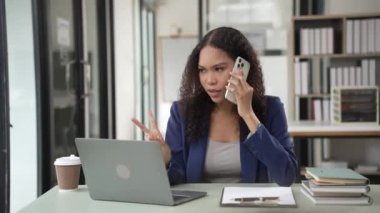 Laptop akıllı telefonu kullanarak gülümseyen genç Afrikalı kadın. Masadaki matematik, vergi hesapları, raporlar, muhasebe, istatistik ve analitik araştırma kavramları, finans 4 bin.