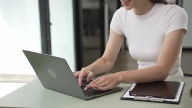 Z jenerasyonundaki kulaklıklı genç kız laptopta internet okuyor. Webinars 'ın sesli anlatımını dinliyor. Notlar yazıyor, podcast dinliyor, dinleme dersleri alıyor.