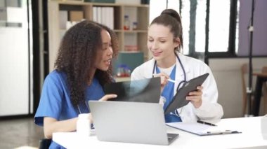 İki kadın doktor virüs testi için kan örnekleriyle test tüplerini inceliyor. Virüs salgınından kalma koruyucu eldivenler, sağlık ve güvenlik konsepti giyiyorlar..