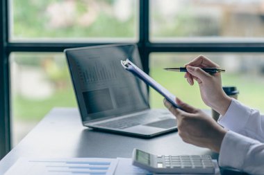 Performans analiz raporunu hazırlayan muhasebeci holding yöneticileri, finansal verileri analiz etmek için çevrimiçi bilgisayar yazılımı kullanarak belge oluşturuyorlar. Yakın plan resimler.