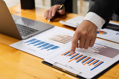 Performans analiz raporunu hazırlayan muhasebeci holding yöneticileri, finansal verileri analiz etmek için çevrimiçi bilgisayar yazılımı kullanarak belge oluşturuyorlar. Yakın plan resimler.