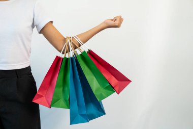 Kadınlar çeşitli renkli alışveriş çantaları taşıyorlar. Alışveriş konseptinin yakın plan fotoğrafı