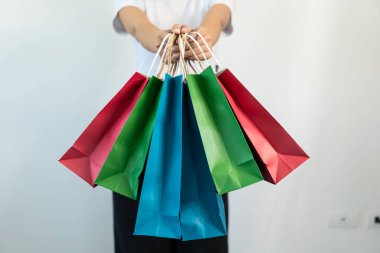 Kadınlar çeşitli renkli alışveriş çantaları taşıyorlar. Alışveriş konseptinin yakın plan fotoğrafı