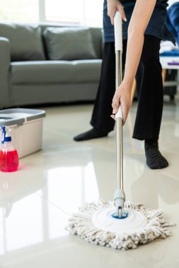 Önlük giyen hizmetçi evde temizlik hizmeti sunuyor. Fotokopi alanında taşınırken yeni bir ev ya da daireyi temizleyen genç bir kadının yakın çekimi