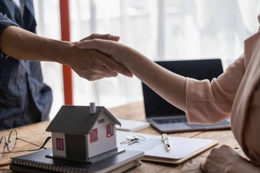 Bir emlakçı, ortaklık ya da sözleşme imzaladıktan sonra bir müşteriyle el sıkışır. iş başarısı konsepti Yakın plan resimler