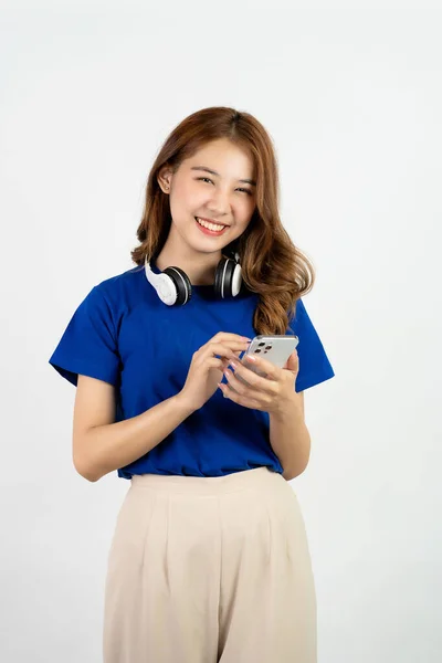 Возбужденная Улыбающаяся Азиатка Держит Мобильный Телефон Выглядит Счастливой Стоя Белом — стоковое фото