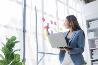 İç işlerinde çalışan Asyalı iş kadını mali belgeleri, hesap makinesini, telefonu, bilgisayarı, masadaki finansal rapor kavramını analiz ediyor. iş planı yatırımı