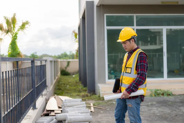 Young man engineer or construction supervisor inspecting work on project, architect wearing helmet and vest doing inspection and inspection. Quality of work done