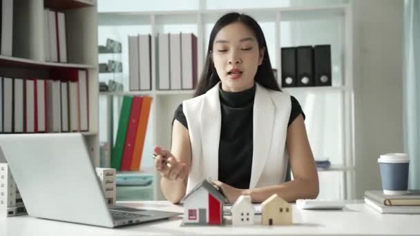 Agen Penjualan Rumah Asia Perempuan Memperkenalkan Sampel Rumah Kepada Pelanggan — Stok Video
