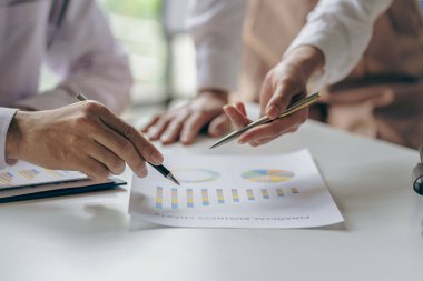 İş adamlarıyla takım çalışması maliyet grafiklerini bir iş konferansı odasında analiz eder ve ofis çalışanları proje planlama belgeleriyle bir konferans masasında çalışır, yakın plan fotoğrafçılık.