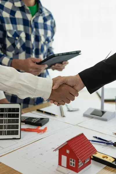 İnşaat sahasındaki anlaşmayı tamamladıktan sonra takım çalışması ve işbirliği konsepti için çalışırken mimar ve inşaat mühendisi el ele tutuşuyor. Yakın plan resimler.