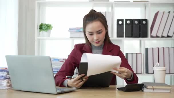 アジアのビジネス女性 テーブル上の文書とオフィスで働いています 財務報告計画を分析する ビジネスプラン投資 若いアジアの女性 販売請求書の会計 — ストック動画