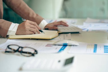 Ofis odasındaki mali verileri analiz etmek için hesap makinesi ve dizüstü bilgisayar kullanan iş kadını muhasebecisine yakın plan. İş dünyası finansmanı, vergiler, kavramlar.