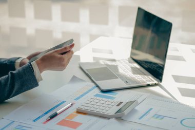 Ofis odasındaki mali verileri analiz etmek için hesap makinesi ve dizüstü bilgisayar kullanan iş kadını muhasebecisine yakın plan. İş dünyası finansmanı, vergiler, kavramlar.