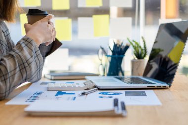 Ofis odasındaki mali verileri analiz etmek için hesap makinesi ve dizüstü bilgisayar kullanan iş kadını muhasebecisine yakın plan. İş dünyası finansmanı, vergiler, kavramlar.