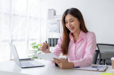 Yıllık özet raporu, masadaki dizüstü bilgisayar ve kağıt, çevrimiçi çalışan Asyalı kadın ve dizüstü bilgisayarla finansal veri planlaması ve heyecanlı ve mutlu yüzle başarılı olması