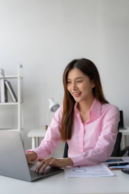 Yıllık özet raporu, masadaki dizüstü bilgisayar ve kağıt, çevrimiçi çalışan Asyalı kadın ve dizüstü bilgisayarla finansal veri planlaması ve heyecanlı ve mutlu yüzle başarılı olması