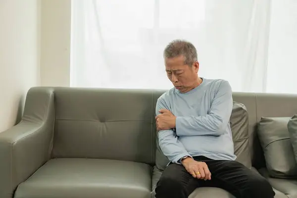 一位年迈的亚洲男性病人患有风湿性关节炎 手部疼痛麻木 年长男子按摩手疼痛腕部健康问题的概念 — 图库照片
