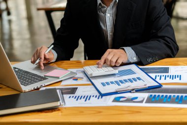 Grafik çizelgelerine işaret eden işadamı veri analizi, veri belgeleri, grafikler, raporlar, piyasa araştırmaları, geliştirme, planlama, yönetim, mali strateji için dizüstü bilgisayar kullanıyor.