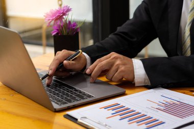 Grafik çizelgelerine işaret eden işadamı veri analizi, veri belgeleri, grafikler, raporlar, piyasa araştırmaları, geliştirme, planlama, yönetim, mali strateji için dizüstü bilgisayar kullanıyor.